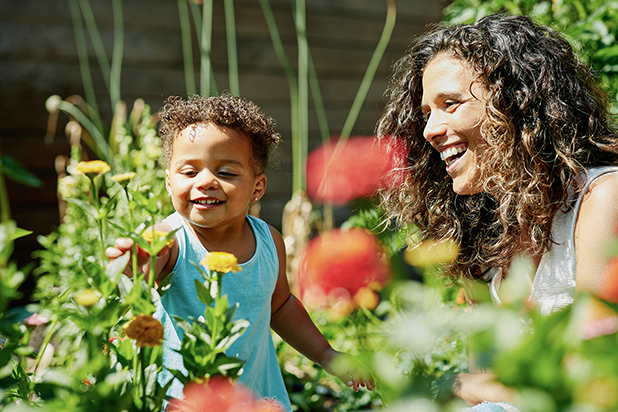 Child in a garden with an adult